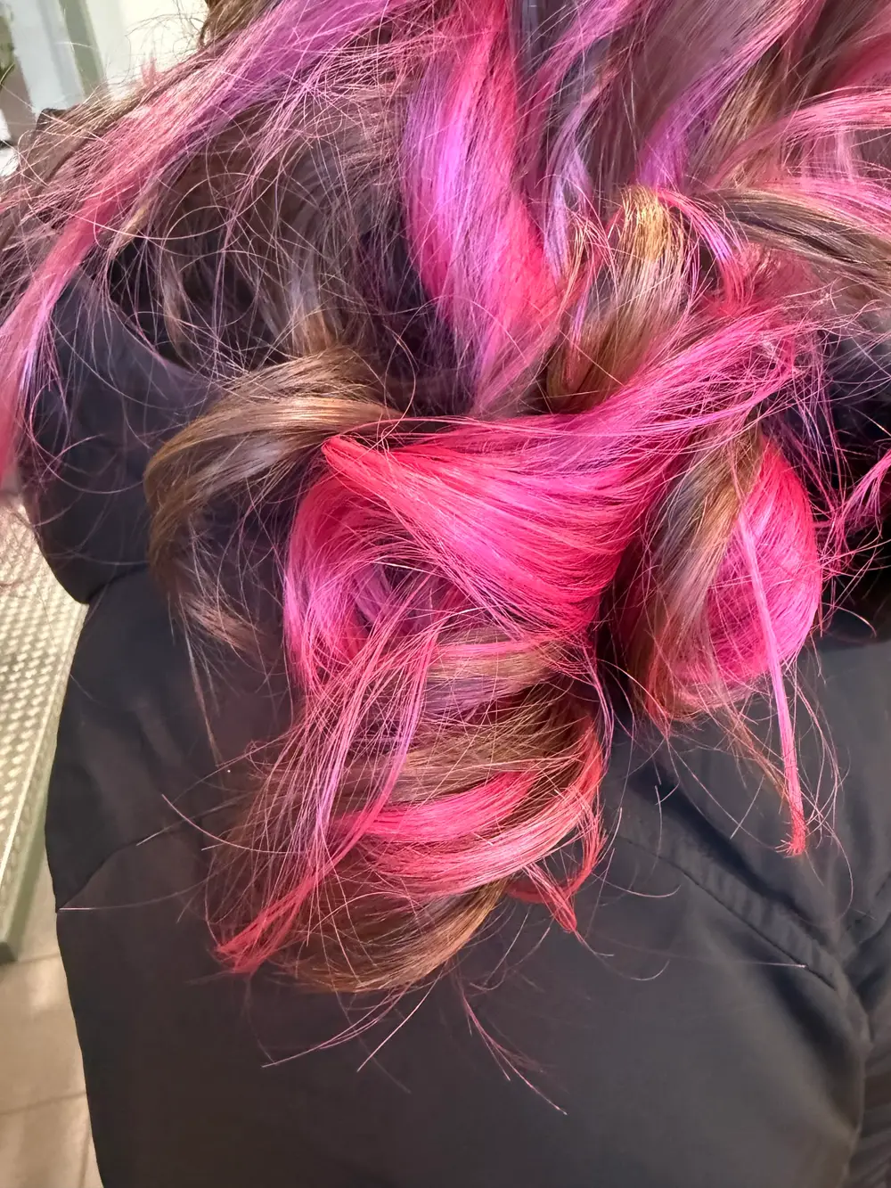 Opgestoken haar met felroze strengen door bruin haar